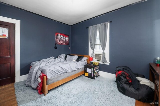 bedroom with cooling unit and dark wood-type flooring