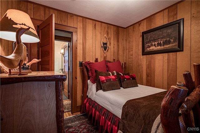 bedroom with ornamental molding, dark wood-type flooring, and wooden walls