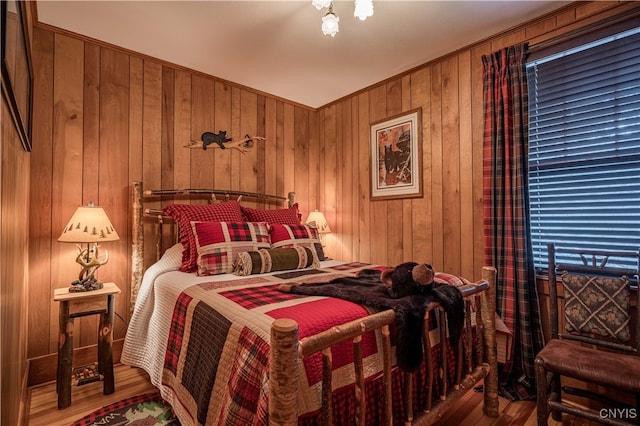 bedroom featuring hardwood / wood-style floors and wooden walls