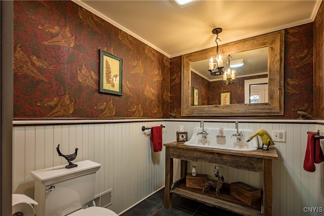 bathroom featuring tile patterned floors, toilet, an inviting chandelier, and ornamental molding