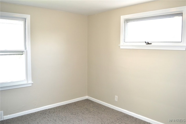 spare room with plenty of natural light and carpet floors