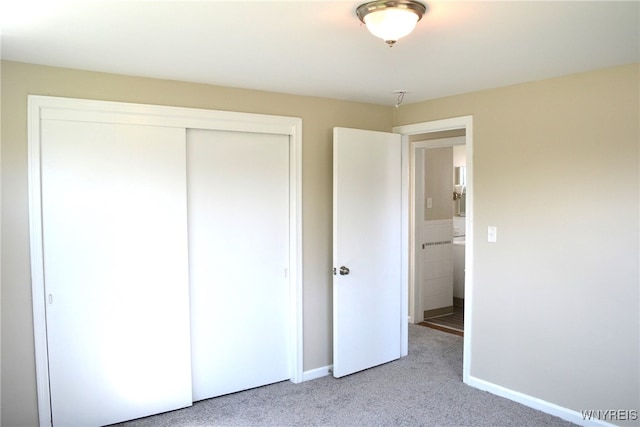 unfurnished bedroom featuring light colored carpet and a closet