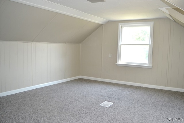 additional living space featuring lofted ceiling and carpet flooring