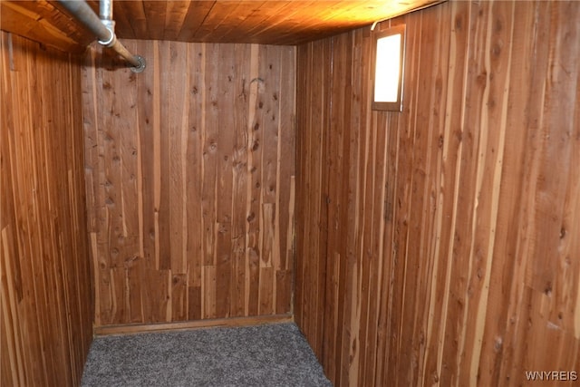 interior space with wooden ceiling, wood walls, and carpet flooring