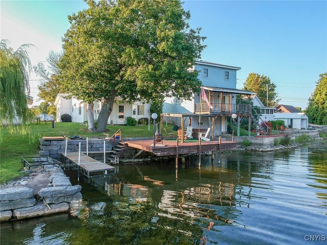 view of dock with a deck with water view and a yard