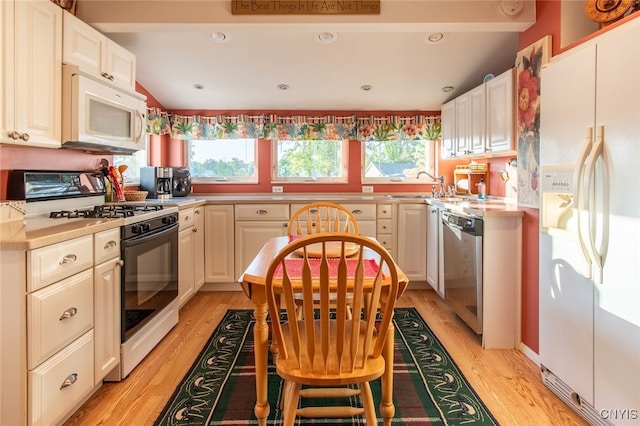 kitchen with white cabinets, white appliances, light hardwood / wood-style floors, and sink