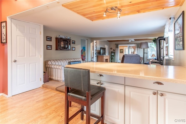 kitchen featuring wooden ceiling, light hardwood / wood-style floors, and white cabinetry