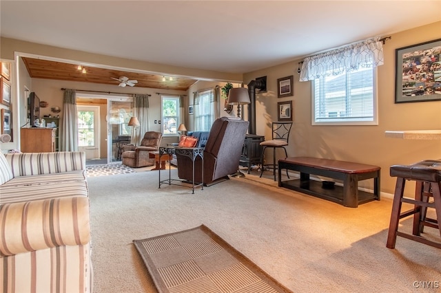 living room featuring carpet flooring, ceiling fan, and beamed ceiling