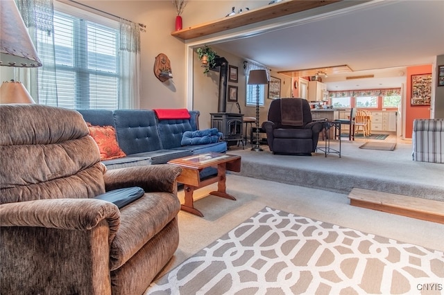 carpeted living room with a wood stove