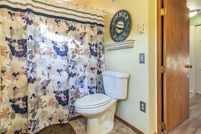 bathroom featuring wood-type flooring and toilet