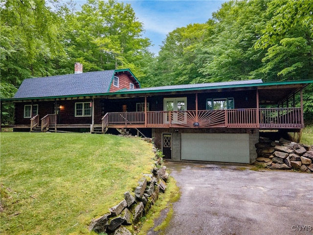 cabin featuring a garage and a front lawn