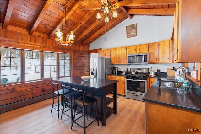 kitchen featuring light wood-type flooring, stainless steel appliances, baseboard heating, hanging light fixtures, and lofted ceiling with beams