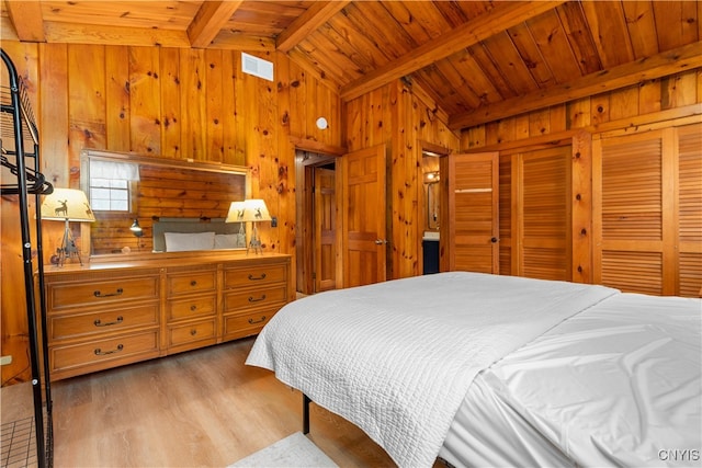 bedroom featuring light hardwood / wood-style flooring, wooden walls, wooden ceiling, and lofted ceiling with beams