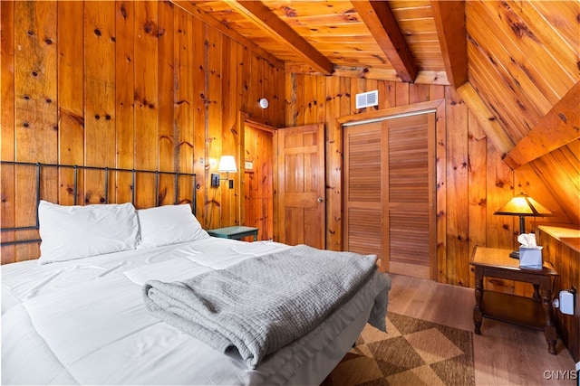 bedroom featuring wood-type flooring, a closet, wooden walls, and lofted ceiling with beams