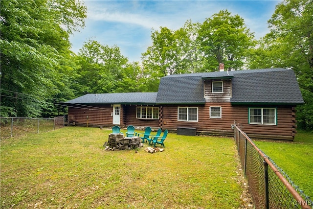 rear view of house featuring a yard, a patio, and an outdoor fire pit