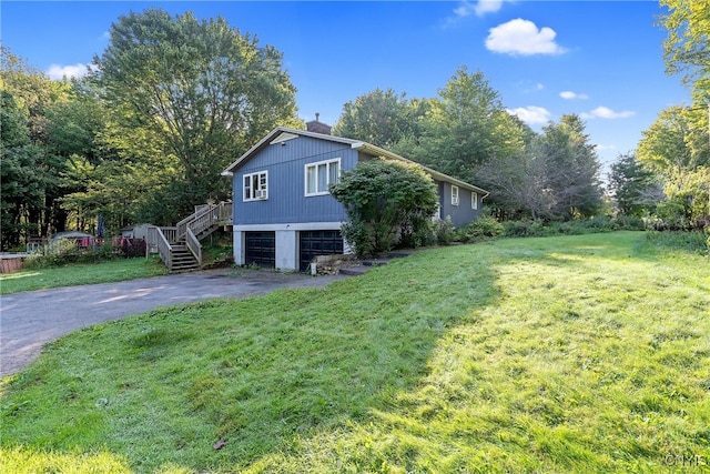 view of side of home featuring a garage and a yard