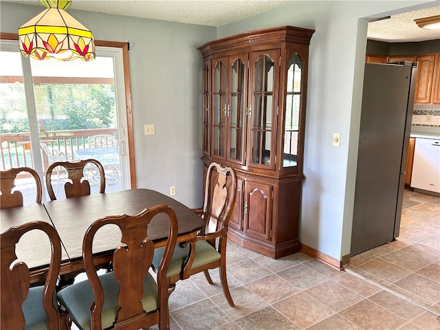 dining area featuring a textured ceiling and light tile patterned floors