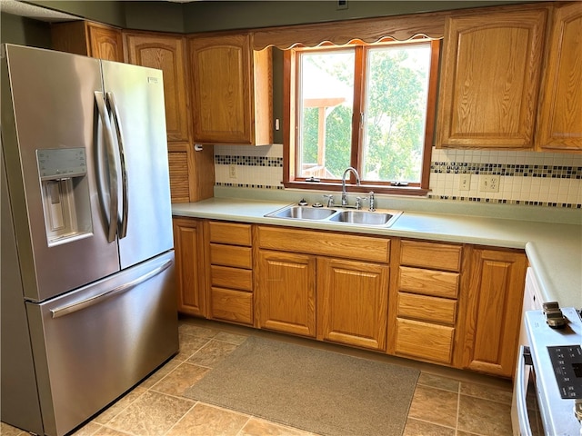 kitchen with stainless steel refrigerator with ice dispenser, backsplash, and sink