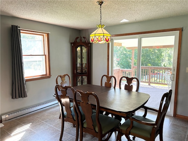 tiled dining space with a textured ceiling and a baseboard radiator