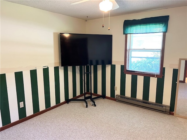 carpeted spare room featuring a baseboard heating unit, ceiling fan, and a textured ceiling