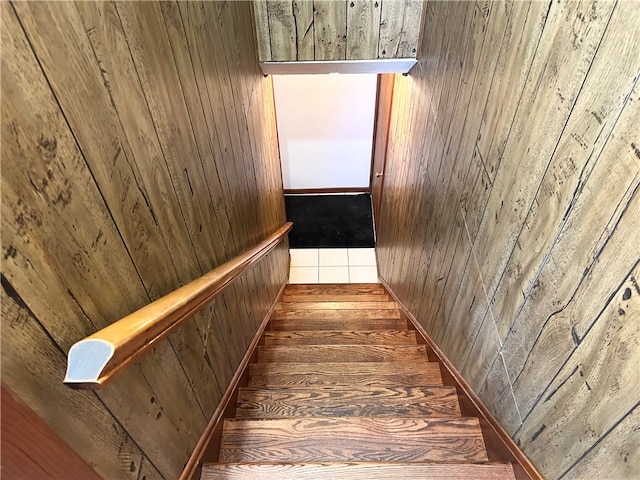 staircase featuring wood walls and tile patterned floors