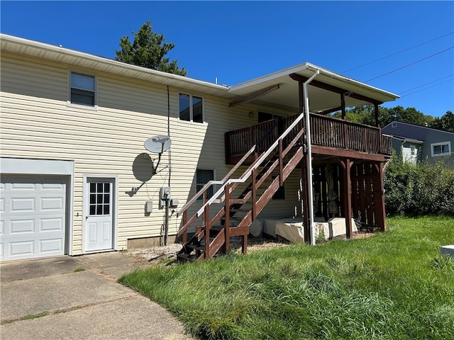 rear view of property with a garage, a lawn, and a deck