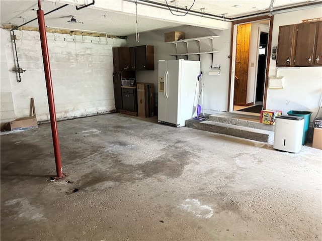 garage featuring white refrigerator with ice dispenser