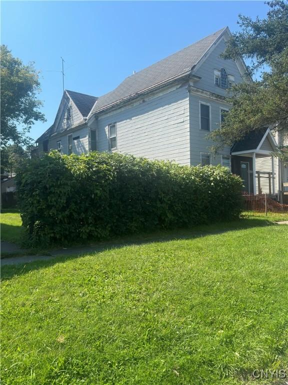 view of side of home with a yard