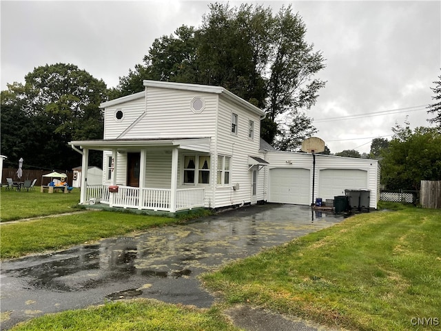 view of front of house featuring a garage, a front lawn, and covered porch