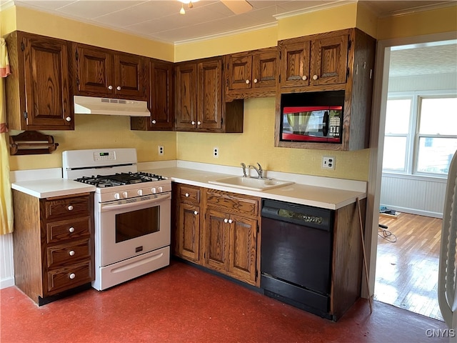 kitchen with crown molding, black appliances, sink, and dark wood-type flooring