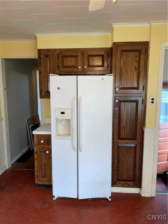 kitchen with dark carpet, white fridge with ice dispenser, and ornamental molding