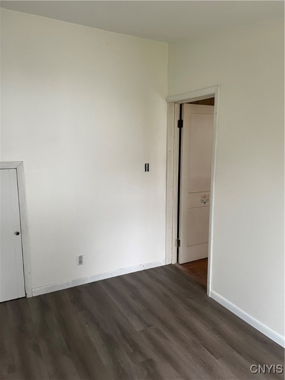 unfurnished room with dark hardwood / wood-style flooring