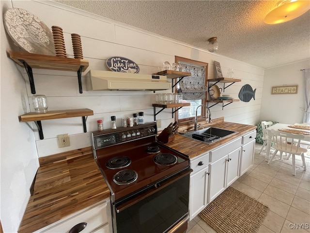 kitchen with a textured ceiling, electric range, sink, white cabinets, and custom exhaust hood