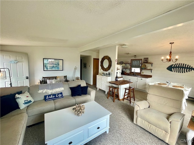 living room featuring light carpet, a textured ceiling, wood walls, and a chandelier