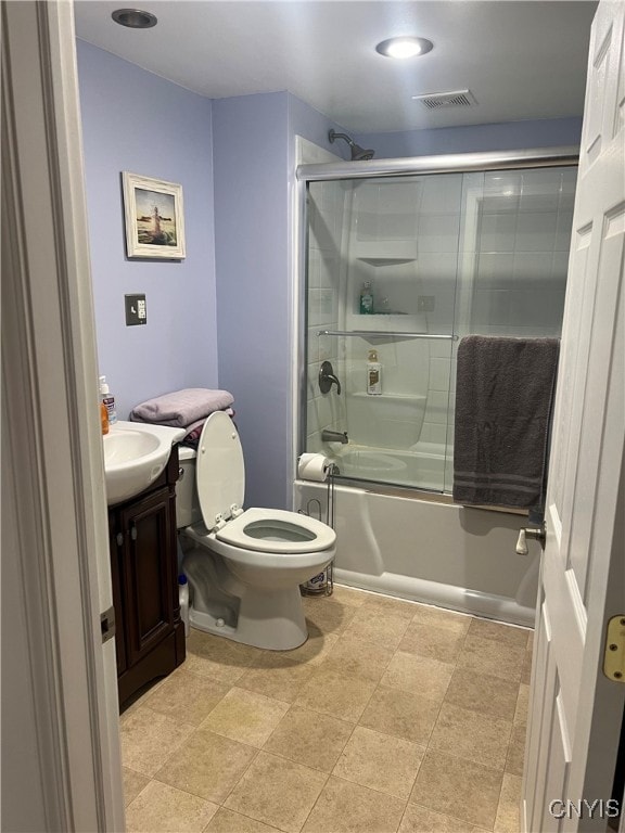 full bathroom featuring toilet, combined bath / shower with glass door, and vanity