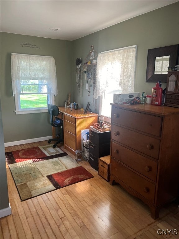 office space with light hardwood / wood-style floors and a healthy amount of sunlight