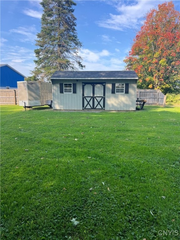 back of house featuring a yard and an outbuilding