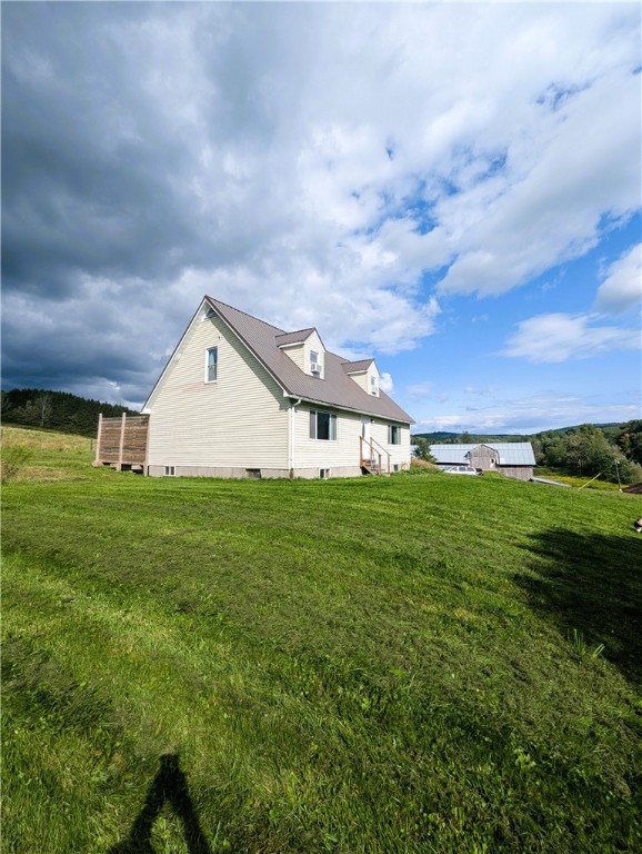 view of side of home with a yard