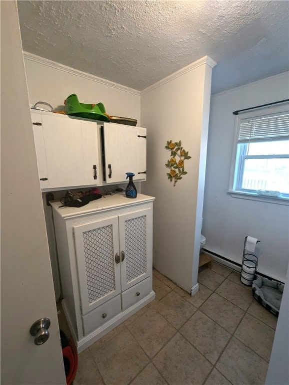 interior space with crown molding, toilet, tile patterned flooring, and a textured ceiling