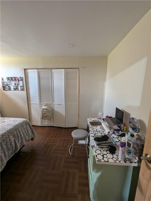 bedroom featuring dark parquet floors and a closet