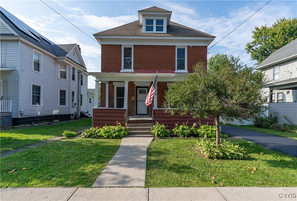 view of front of property with covered porch and a front lawn