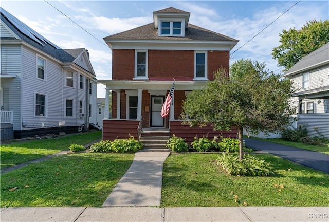 view of front of property with covered porch and a front lawn