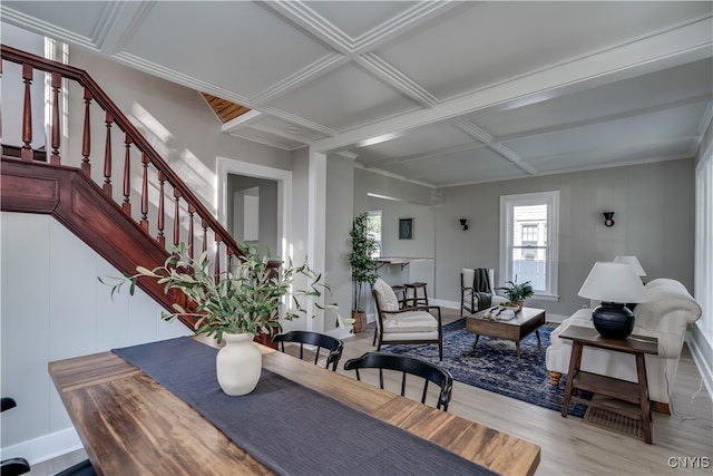 dining space with light wood-type flooring, coffered ceiling, crown molding, and beamed ceiling