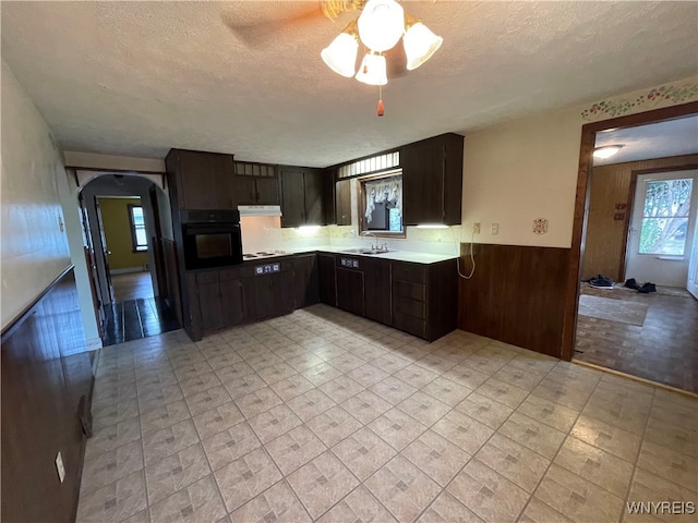 kitchen featuring ceiling fan, dark brown cabinets, a textured ceiling, black oven, and white gas stovetop