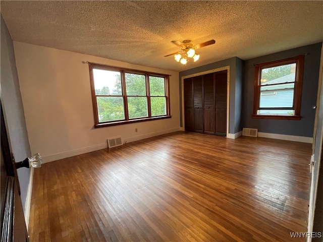 unfurnished bedroom featuring a closet, hardwood / wood-style floors, a textured ceiling, and ceiling fan