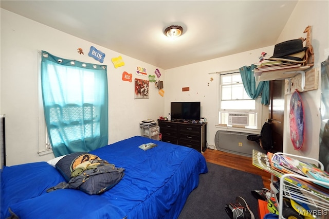 bedroom with cooling unit and hardwood / wood-style flooring