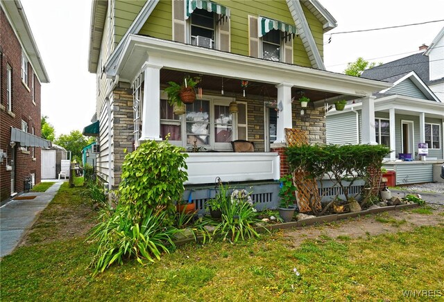 view of front of home with a porch and a front yard