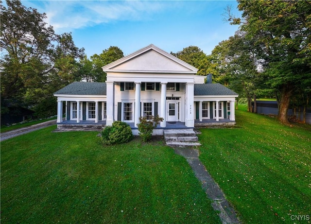 neoclassical home with a front lawn, covered porch, and roof with shingles