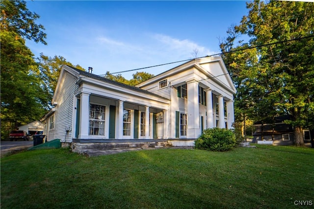 neoclassical home featuring a front lawn