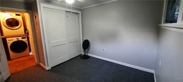 clothes washing area with laundry area, stacked washer / drying machine, dark carpet, and ceiling fan
